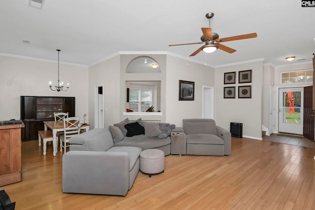 living room with crown molding, ceiling fan with notable chandelier, and light wood-type flooring