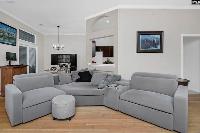 living room with a chandelier, ornamental molding, and light hardwood / wood-style flooring