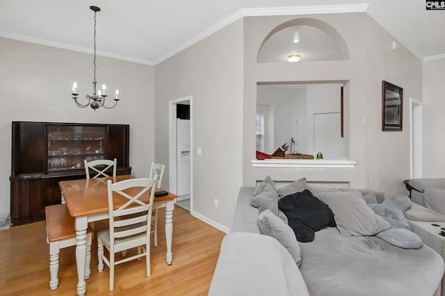 dining area featuring a chandelier, wood-type flooring, vaulted ceiling, and ornamental molding