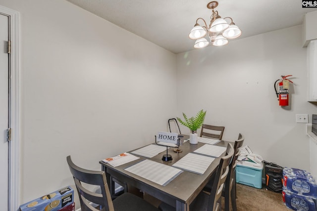 dining room with carpet flooring and an inviting chandelier