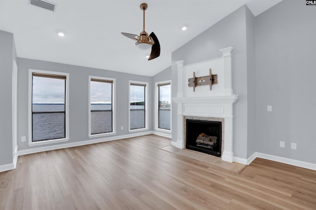 unfurnished living room with ceiling fan, light hardwood / wood-style floors, and lofted ceiling