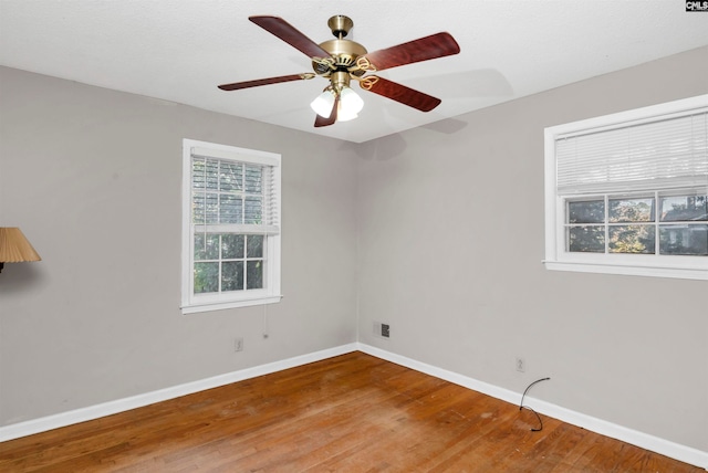 empty room with ceiling fan and hardwood / wood-style floors