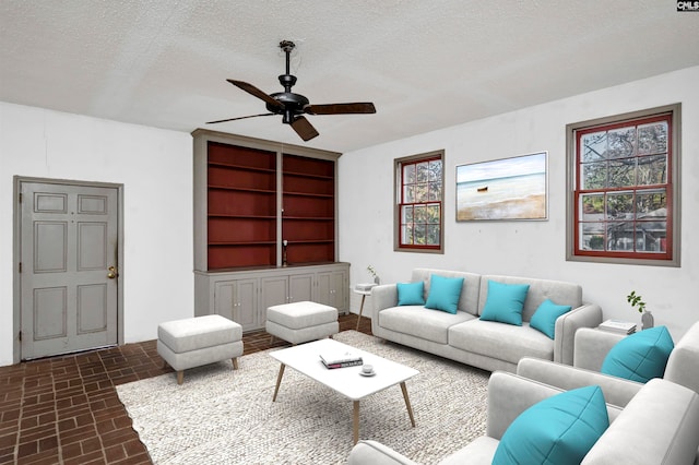 living room with ceiling fan and a textured ceiling