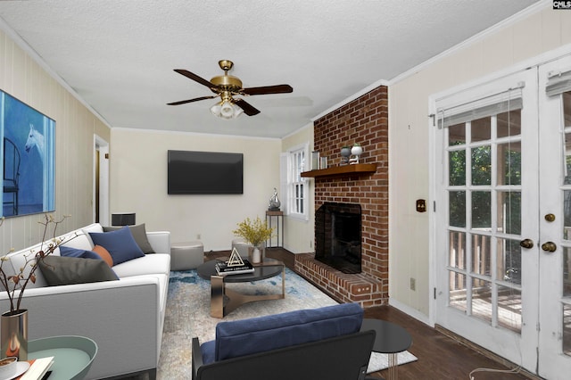 living room featuring dark hardwood / wood-style flooring, crown molding, a wealth of natural light, and a brick fireplace