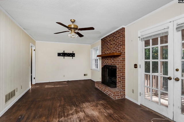 unfurnished living room with ceiling fan, dark hardwood / wood-style flooring, crown molding, and a brick fireplace