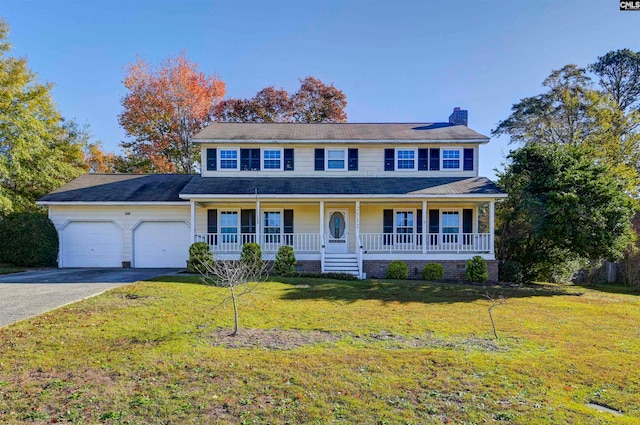 colonial house featuring a front yard, a porch, and a garage