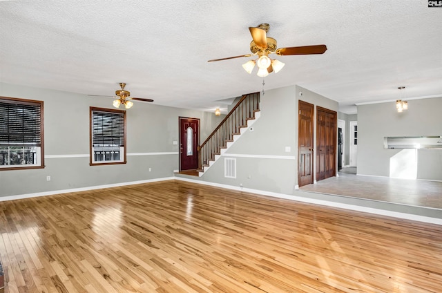 unfurnished living room with ceiling fan, light hardwood / wood-style flooring, and a textured ceiling