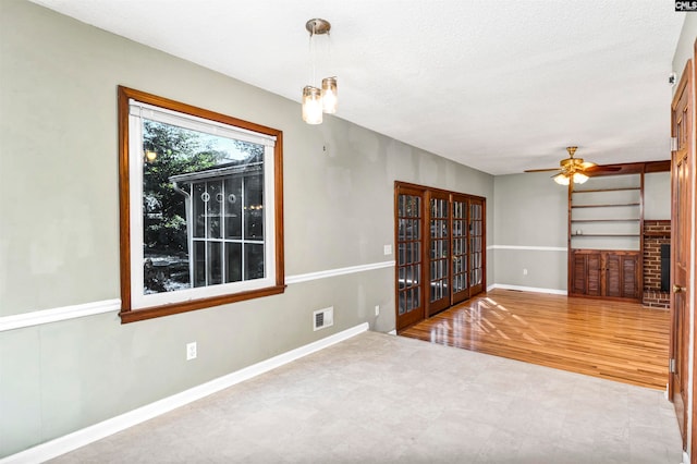 unfurnished room with hardwood / wood-style floors, ceiling fan, and a textured ceiling