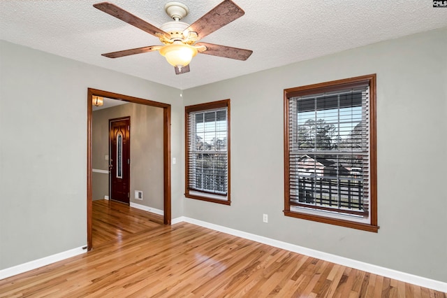 unfurnished room featuring ceiling fan, light hardwood / wood-style floors, and a textured ceiling