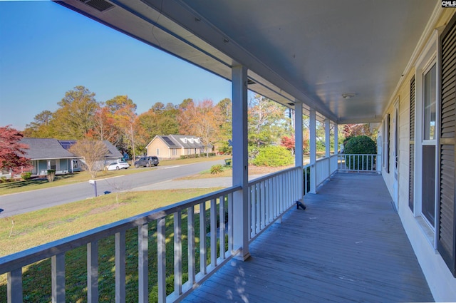 wooden terrace with a porch and a yard