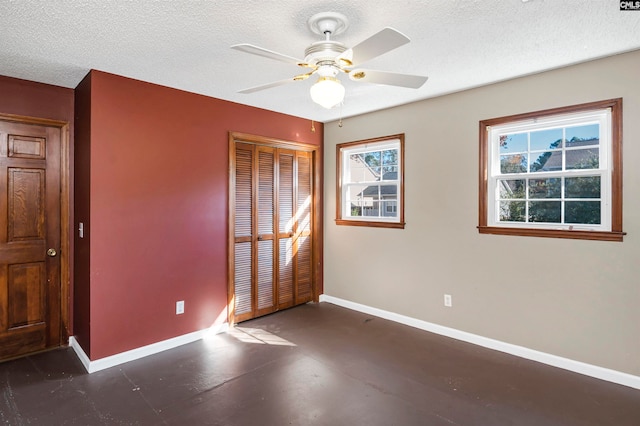 unfurnished bedroom with a textured ceiling, a closet, and ceiling fan