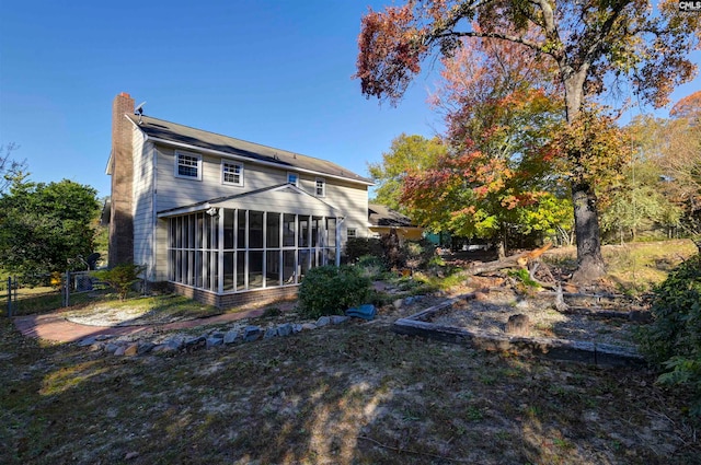 rear view of house featuring a sunroom