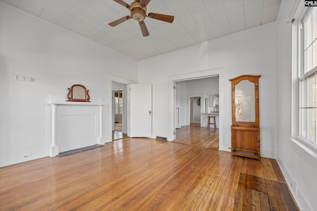 unfurnished living room with ceiling fan and hardwood / wood-style floors