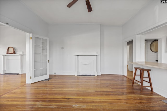 unfurnished living room with hardwood / wood-style flooring, ceiling fan, and ornamental molding