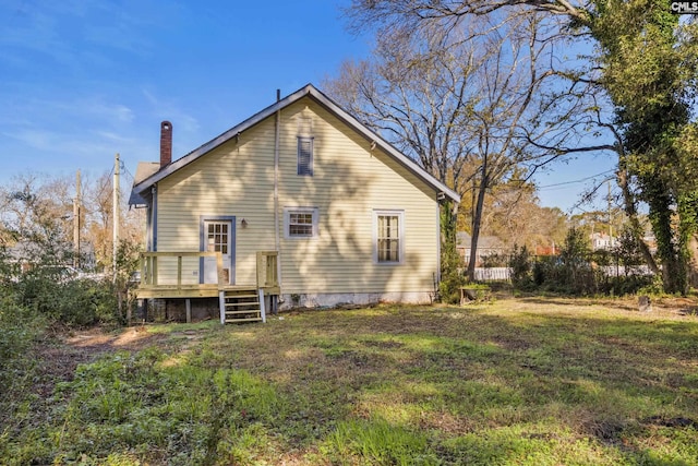 back of house featuring a wooden deck and a yard