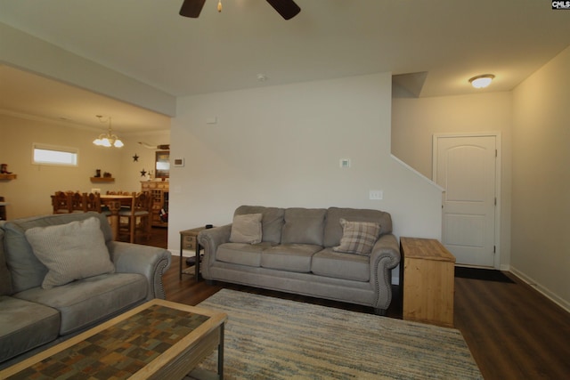 living room with ceiling fan with notable chandelier and dark wood-type flooring