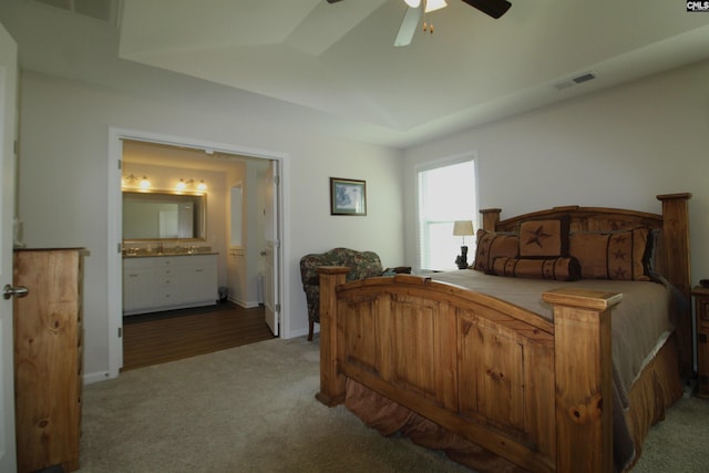 bedroom with carpet floors, ensuite bathroom, and ceiling fan