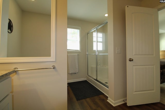 bathroom with vanity, an enclosed shower, and hardwood / wood-style flooring