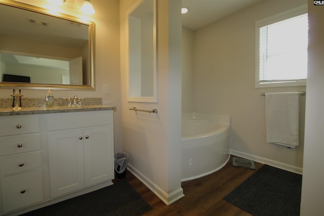 bathroom with a bath, vanity, and wood-type flooring