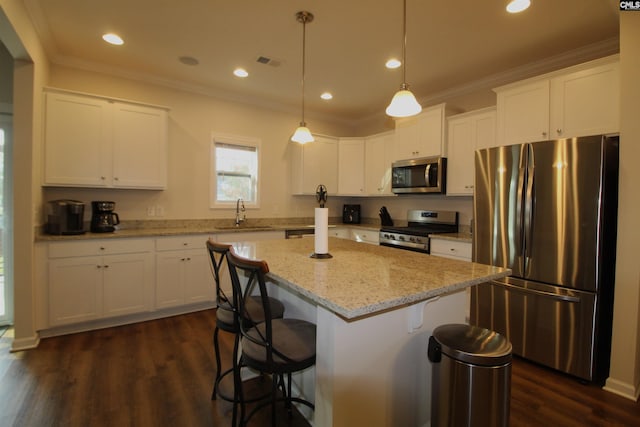 kitchen with pendant lighting, a kitchen island, dark hardwood / wood-style flooring, white cabinetry, and stainless steel appliances