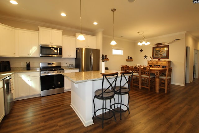 kitchen with white cabinetry, stainless steel appliances, an inviting chandelier, pendant lighting, and a kitchen island