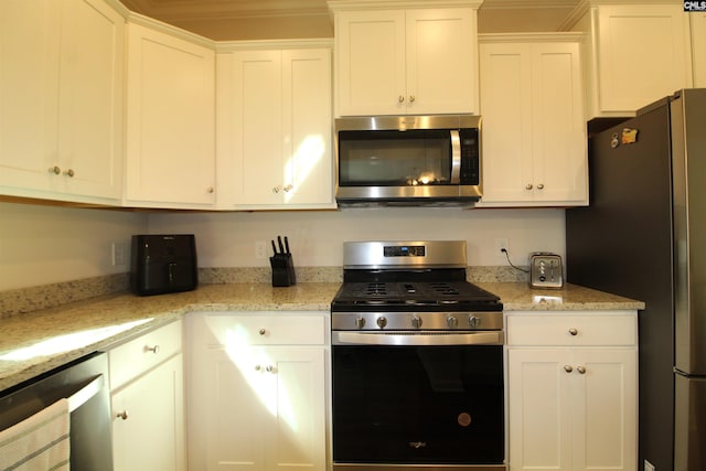 kitchen featuring light stone counters, white cabinetry, and appliances with stainless steel finishes