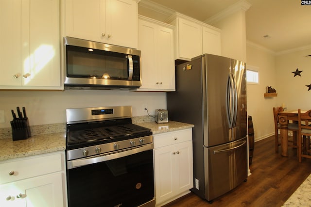 kitchen featuring white cabinets, stainless steel appliances, light stone countertops, and ornamental molding