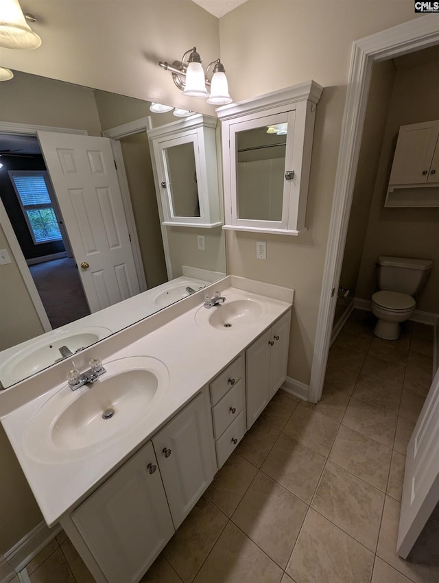 bathroom with tile patterned floors, vanity, toilet, and a notable chandelier