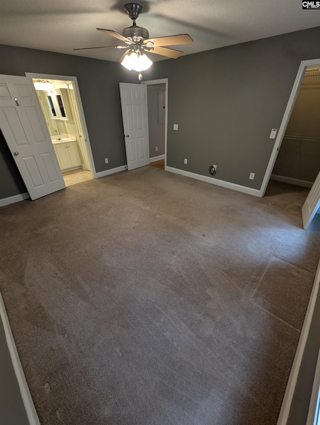 unfurnished bedroom featuring carpet, ceiling fan, a textured ceiling, and ensuite bath