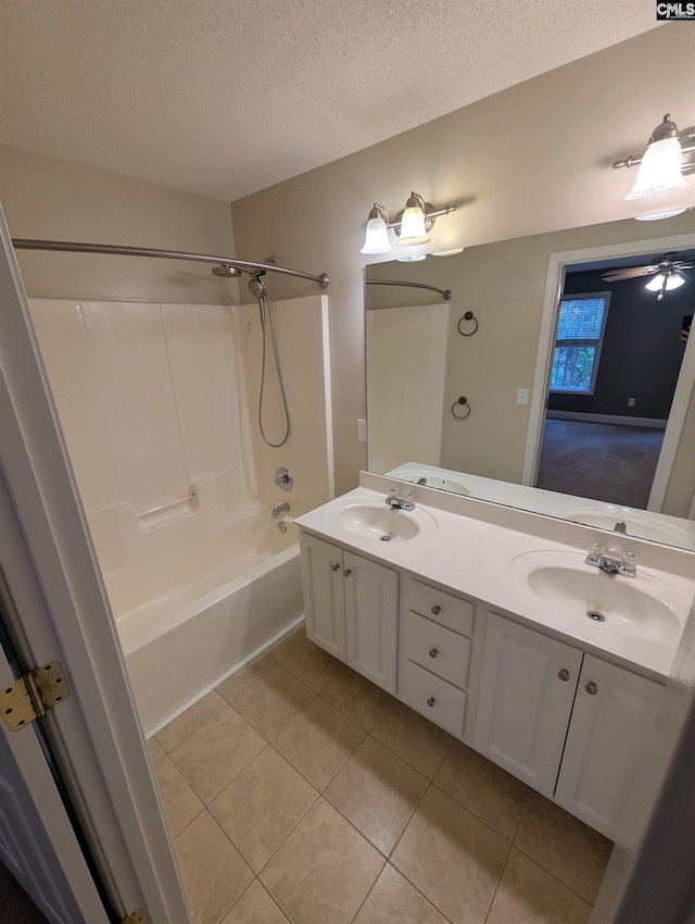 bathroom featuring ceiling fan, tile patterned floors, a textured ceiling, vanity, and shower / bathtub combination