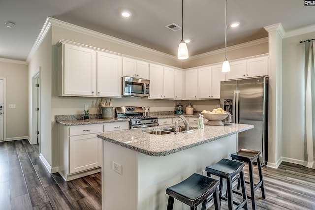 kitchen with dark wood-type flooring, white cabinets, hanging light fixtures, sink, and appliances with stainless steel finishes