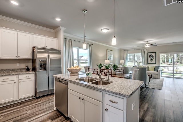 kitchen with stainless steel appliances, ceiling fan, sink, white cabinets, and an island with sink