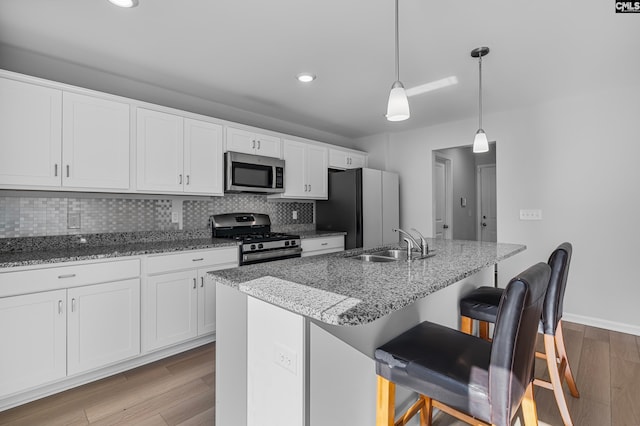 kitchen featuring light hardwood / wood-style flooring, sink, appliances with stainless steel finishes, and an island with sink