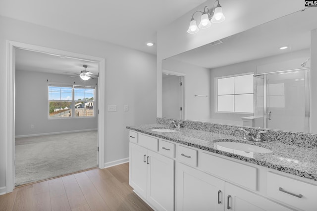 bathroom featuring ceiling fan, vanity, wood-type flooring, and a shower with shower door