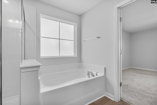 bathroom with a bathing tub and wood-type flooring