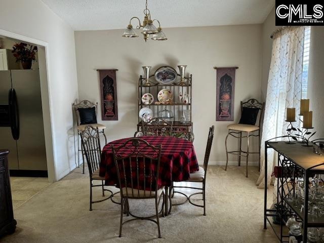 dining space with light carpet and a notable chandelier