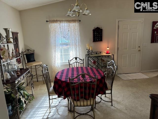 carpeted dining room featuring a chandelier and lofted ceiling