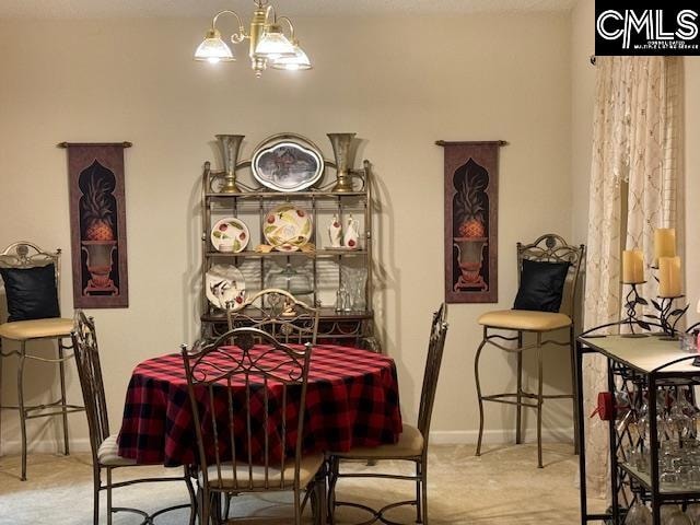 dining space featuring light colored carpet and a notable chandelier