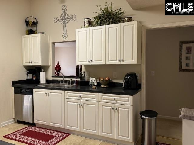 kitchen with white cabinets, light tile patterned flooring, stainless steel dishwasher, and sink