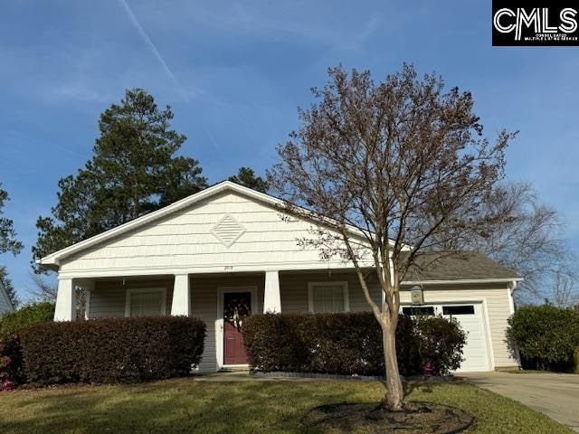 view of front of property featuring a porch, a front yard, and a garage