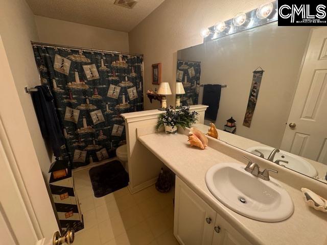 bathroom with walk in shower, vanity, a textured ceiling, and toilet