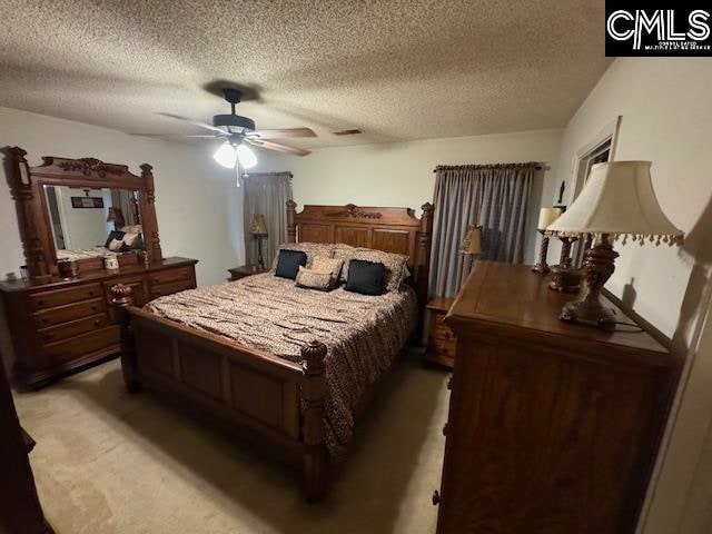 carpeted bedroom with a textured ceiling and ceiling fan