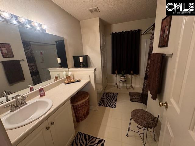 bathroom featuring vanity, a shower with shower curtain, a textured ceiling, and toilet