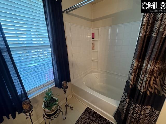 bathroom featuring tile patterned floors and shower / bath combo with shower curtain