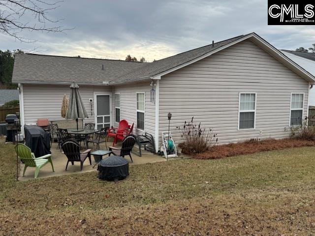 back of property with a yard and a patio