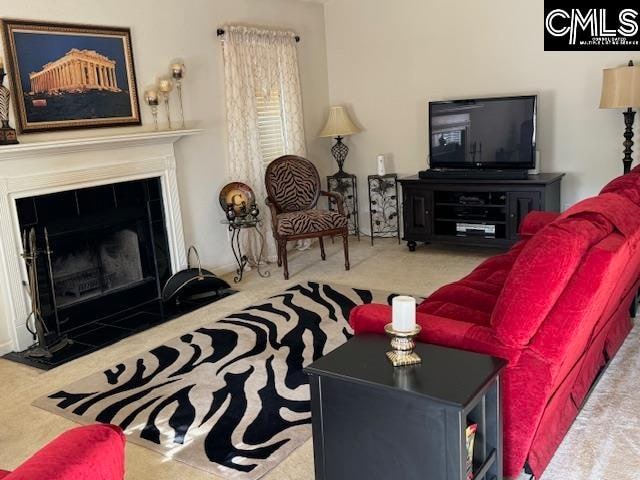 carpeted living room featuring a tiled fireplace