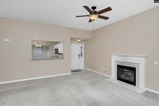 unfurnished living room with light colored carpet and ceiling fan