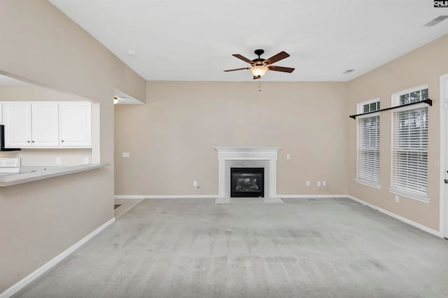 unfurnished living room featuring ceiling fan and light carpet