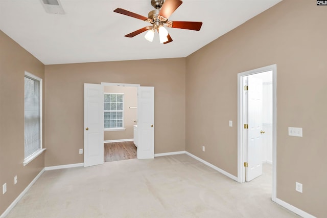 carpeted spare room with ceiling fan and lofted ceiling