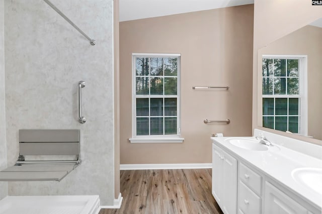 bathroom with plenty of natural light, vanity, lofted ceiling, and hardwood / wood-style flooring